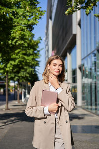 Portrait of young woman standing on street