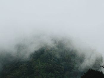 Scenic view of fog on mountain against sky