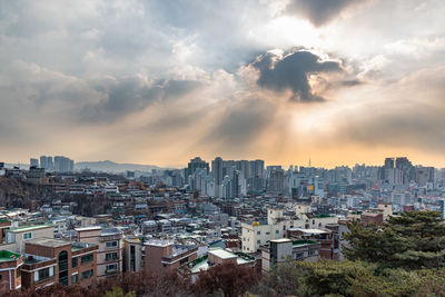 Buildings in city against sky during sunset