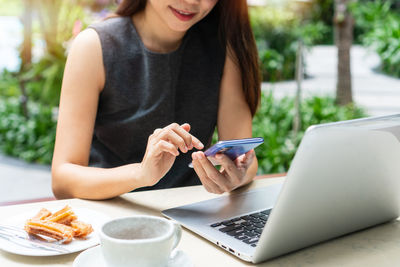 Midsection of woman using mobile phone