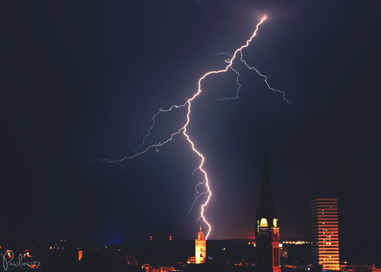 night, illuminated, sky, building exterior, lightning, built structure, low angle view, architecture, thunderstorm, power in nature, city, outdoors, electricity, no people, storm cloud, cityscape, dark, star - space, light - natural phenomenon, storm