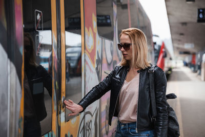 Portrait of young woman standing in train