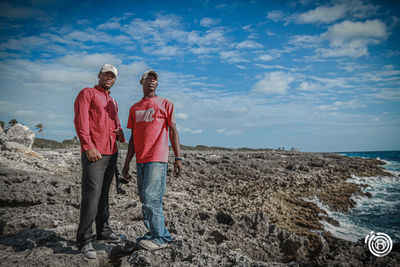 People standing on beach against sky