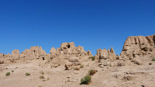 Panoramic view of rocks against clear blue sky