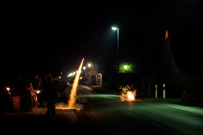 Illuminated street light in city at night