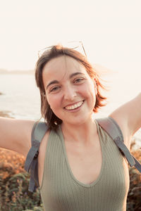 Portrait of young woman standing at beach