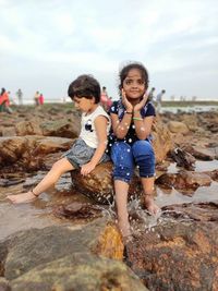 Full length of siblings at beach