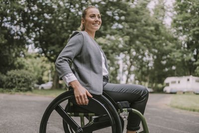 Happy young businesswoman sitting in wheelchair