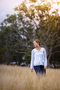 Smiling mid adult woman standing on grassy field