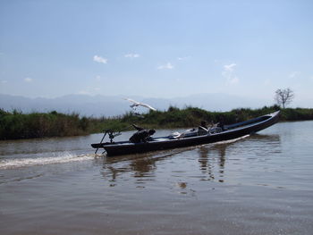 Man in boat on water against sky