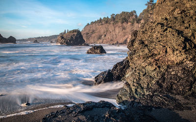 Scenic view of coastline against blue sky