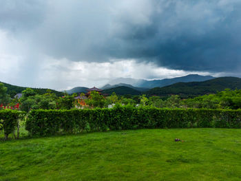 Scenic view of green landscape and mountains against sky