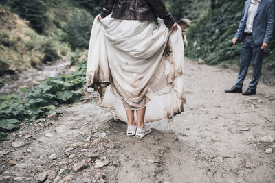 Low section of woman standing on dirt road