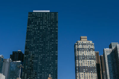 Low angle view of buildings against clear blue sky