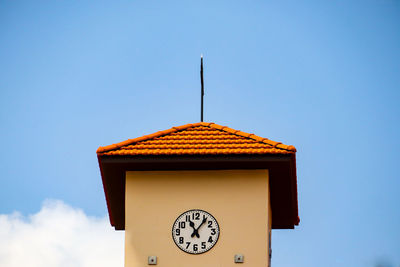 Low angle view of clock on building against clear sky