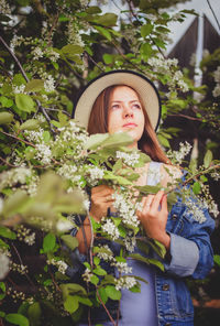 Portrait of young woman with hat on plants