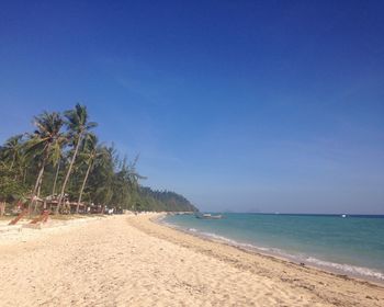 Scenic view of beach against clear blue sky