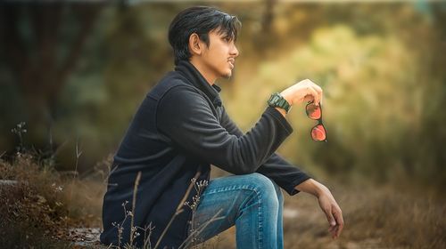 Side view of man sitting in the park