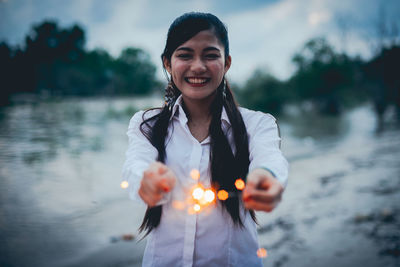 Portrait of smiling young woman standing in lake