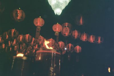 Close-up of illuminated lighting equipment hanging at night