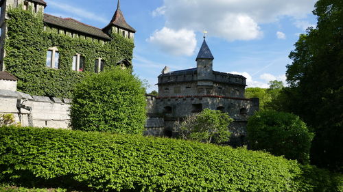 Castle by tree against sky