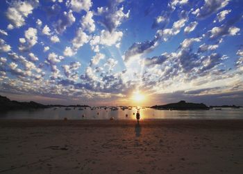 Silhouette person standing at beach during sunset