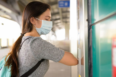 Portrait of young woman standing by train