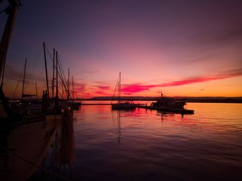 Spectacular sunset through boats at the port of ortigia syracuse