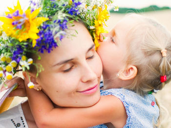 Close-up of mother embracing cute girl 