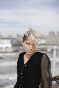 Portrait of woman standing at shore against sky