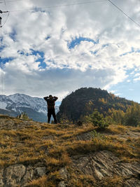 Man standing on mountain against sky