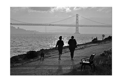 People on suspension bridge over sea