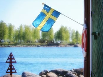 Swedish flag on pole by river