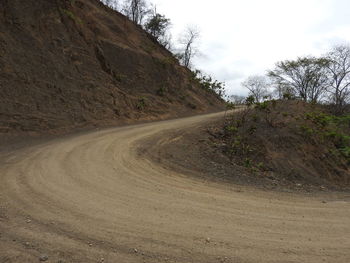 Road amidst trees against sky