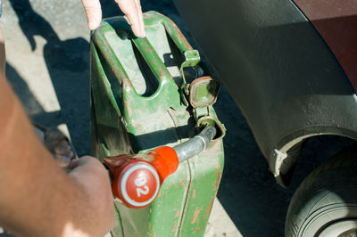Cropped image of man filling gasoline in container