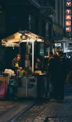 People standing on street at night