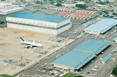 High angle view of airplane flying over cityscape