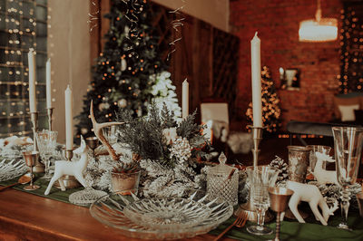 Chic christmas table setting in beige and wooden colors, glassware, candles. christmas interior