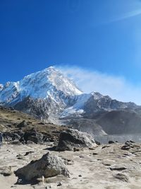 Scenic view of snowcapped mountains against blue sky