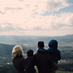 Rear view of a family looking at landscape from the top of a mountain