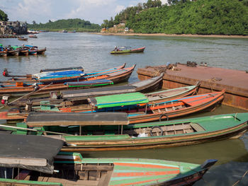 Boats moored at sea shore against sky