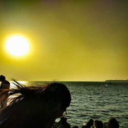 Silhouette woman by sea against sky during sunset