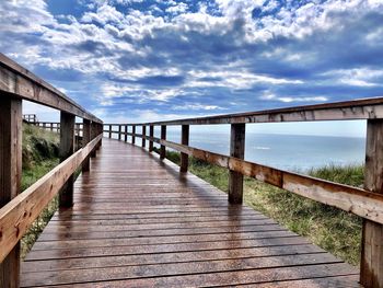 Footbridge over pier against sky