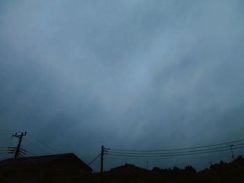 Low angle view of silhouette electricity pylon against sky