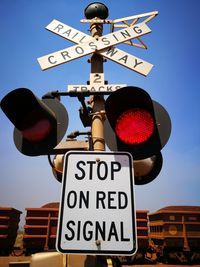 Low angle view of road sign against blue sky