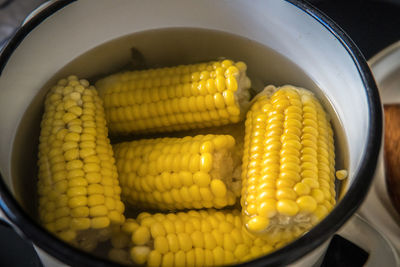 High angle view of yellow and vegetables in container