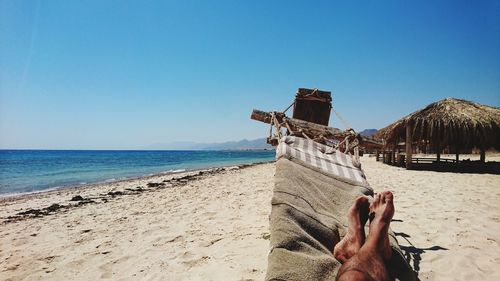 Low section of man relaxing at beach