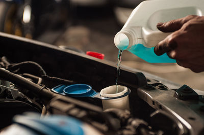 Close-up of hand pouring petrol in car