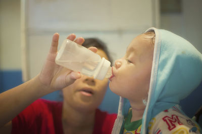 Mother feeding son with bottle