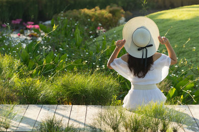 Rear view of woman with umbrella on field